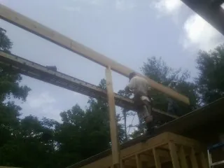 Carpenter setting a ridge beam over a new addition frame — Ice Dam Removal by Roofing Brothers in Mukwonago