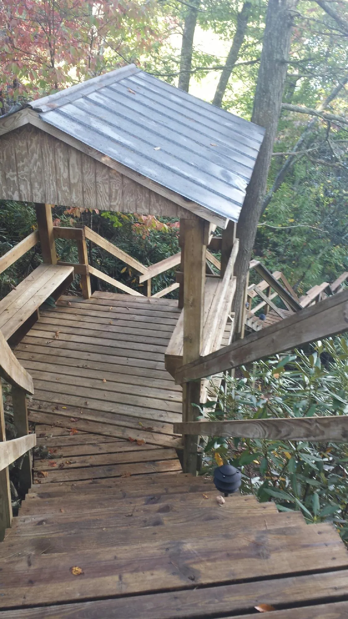 Metal roofed shelter over wooden steps on a wooded walkway — Skylight Repair & Installation work by our crew in Mukwonago