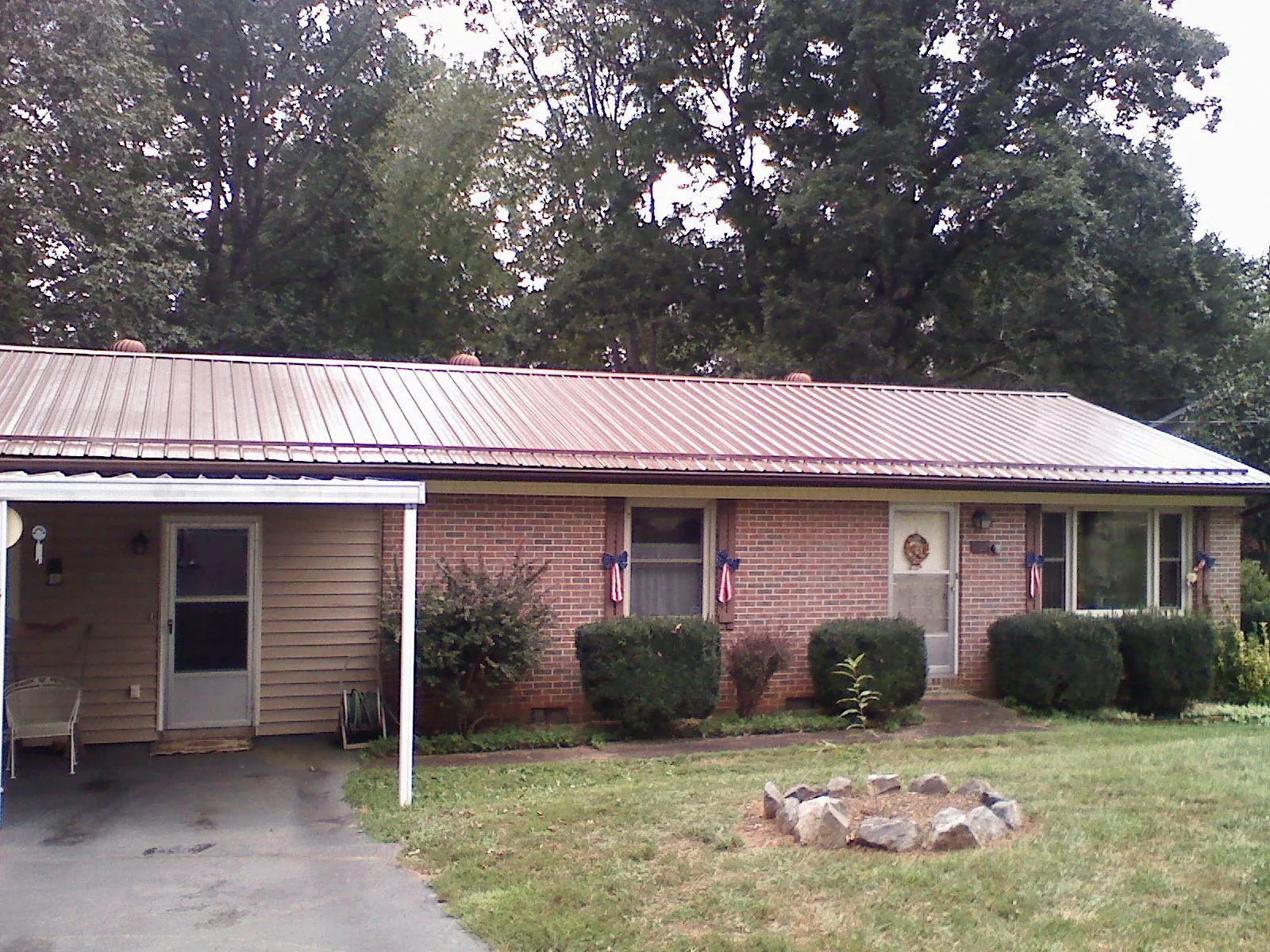Bronze metal roof and carport on a brick ranch home — Roof Repair work by our crew in Mukwonago